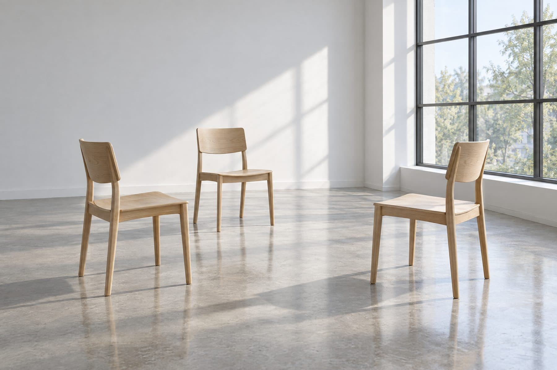 Three timber chairs in a bright, empty room.
